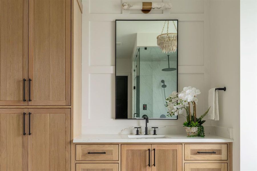 Bathroom featuring vanity and a marble finish shower Bathroom featuring vanity and a marble finish shower