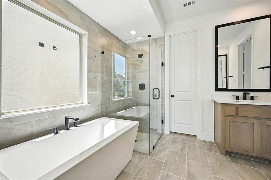 Bathroom featuring a freestanding bath, vanity, a shower stall, tile walls, and recessed lighting Bathroom featuring a freestanding bath, vanity, a shower stall, tile walls, and recessed lighting