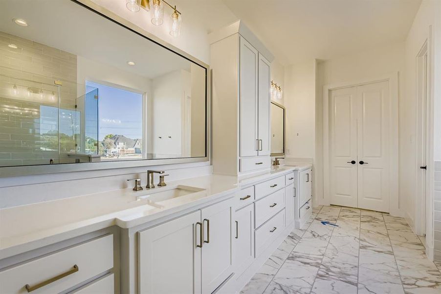 Full bath with a stall shower, double vanity, light marble finish floors, and recessed lighting Full bath with a stall shower, double vanity, light marble finish floors, and recessed lighting