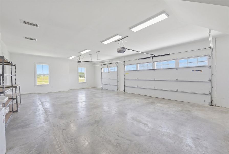Ample windows and bright overhead lighting illuminate this spacious, versatile garage.