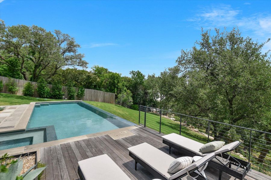 Rectangular swimming pool with integrated spa and stone coping