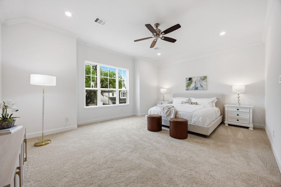 Primary Retreat: A spaciously lit sanctuary, complete with a ceiling fan for personalized comfort and views overlooking the front of the home.