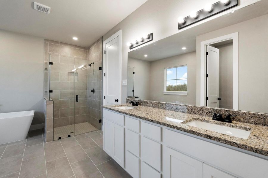 Full bath with double vanity, a shower stall, a soaking tub, light tile patterned floors, and recessed lighting