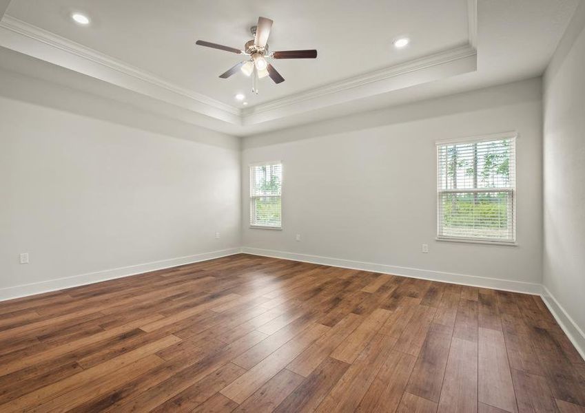 The master bedroom has wood floors, tons of natural light and a ceiling fan.