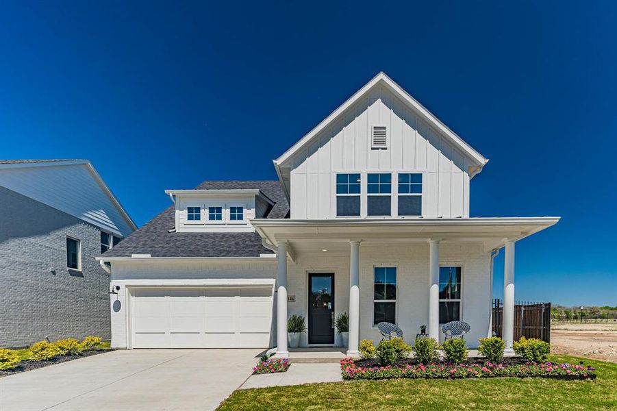 View of front of home with a garage and a porch