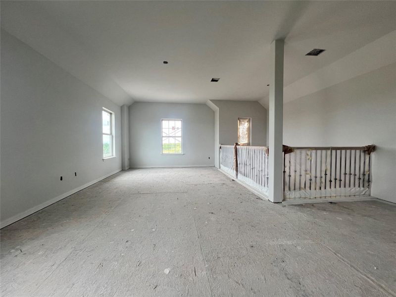Unfurnished room with lofted ceiling and baseboards
