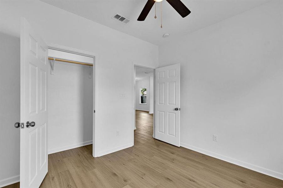 Unfurnished bedroom featuring light wood-style flooring, ceiling fan, and a closet Unfurnished bedroom featuring light wood-style flooring, ceiling fan, and a closet