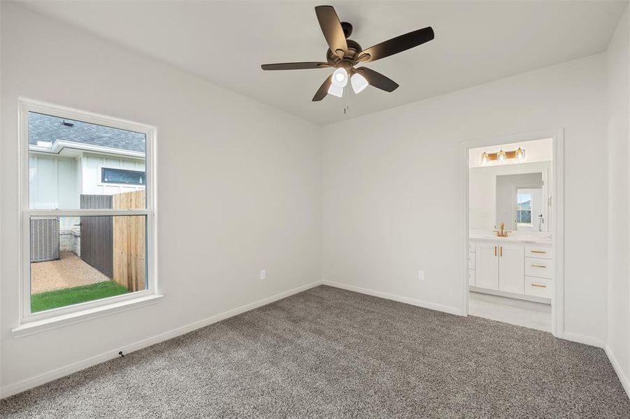 Unfurnished bedroom featuring light colored carpet, ceiling fan, and ensuite bathroom Unfurnished bedroom featuring light colored carpet, ceiling fan, and ensuite bathroom