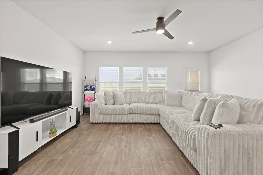 Light, bright, and airy! This is the first of two spacious living areas, featuring gorgeous wood-style flooring and large windows that soak the open-concept heart of the home in Texas sunshine.