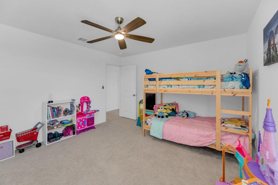 Bedroom featuring a ceiling fan, carpet, and visible vents