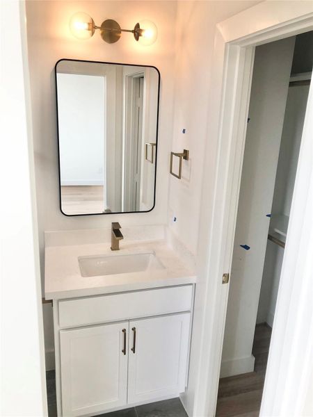 First floor en-suite bath with mirror and hardware installed (EXAMPLE). Buyer may select their own mirror and hardware with seller credit and builder to install.