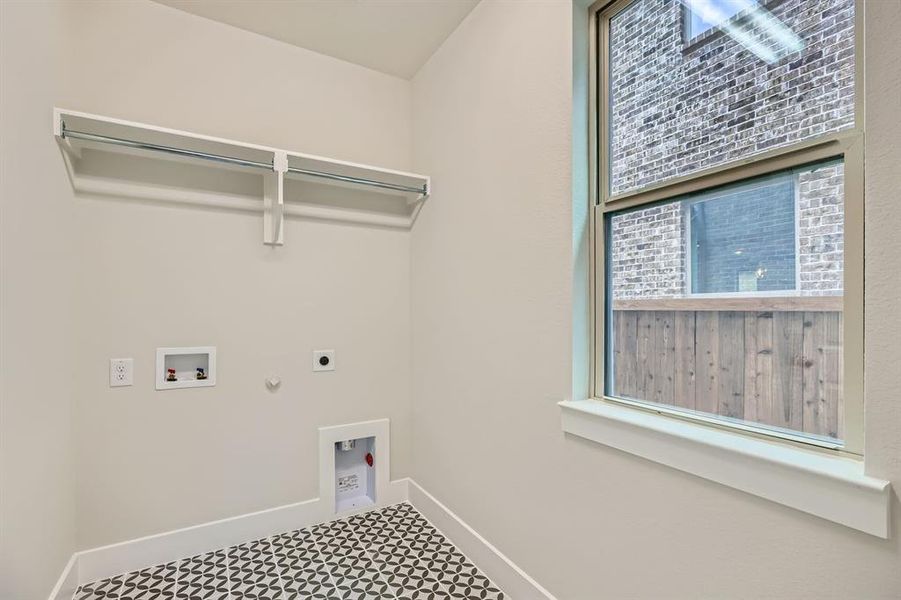 Washroom with hookup for an electric dryer, hookup for a gas dryer, tile patterned floors, and washer hookup