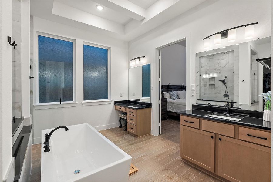 The first floor primary suite is at the back of the house offering added privacy and boasts dual vanities, soaking tub, oversized glass shower, and walk-in closet. The first floor primary suite is at the back of the house offering added privacy and boasts dual vanities, soaking tub, oversized glass shower, and walk-in closet.