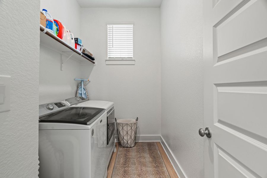 Washroom with light wood finished floors, a textured wall, and separate washer and dryer Washroom with light wood finished floors, a textured wall, and separate washer and dryer