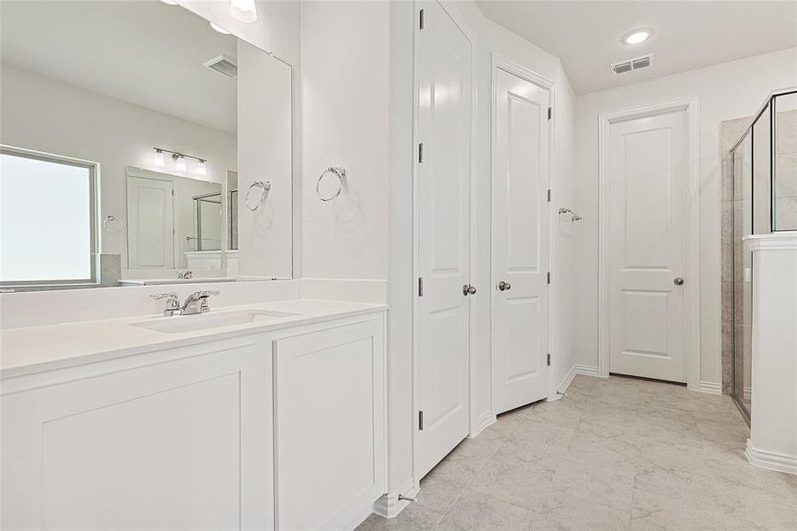 Full bathroom with vanity, a shower stall, recessed lighting, and a closet
