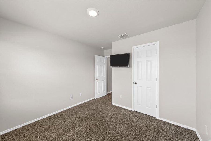 Unfurnished bedroom with dark colored carpet and baseboards Unfurnished bedroom with dark colored carpet and baseboards