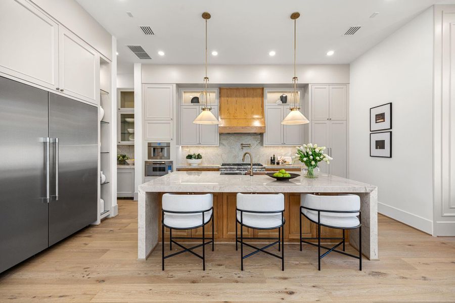 Chef's Kitchen offers extra large stainless sink, 48 in Range w/ double over, venthood w/ beautifully stained cover & pot filler. Backsplash is matching Taj Mahal quartz. Butler's Pantry & Walk-in pantry between formal dining & Kitchen. Chef's Kitchen offers extra large stainless sink, 48 in Range w/ double over, venthood w/ beautifully stained cover & pot filler. Backsplash is matching Taj Mahal quartz. Butler's Pantry & Walk-in pantry between formal dining & Kitchen.