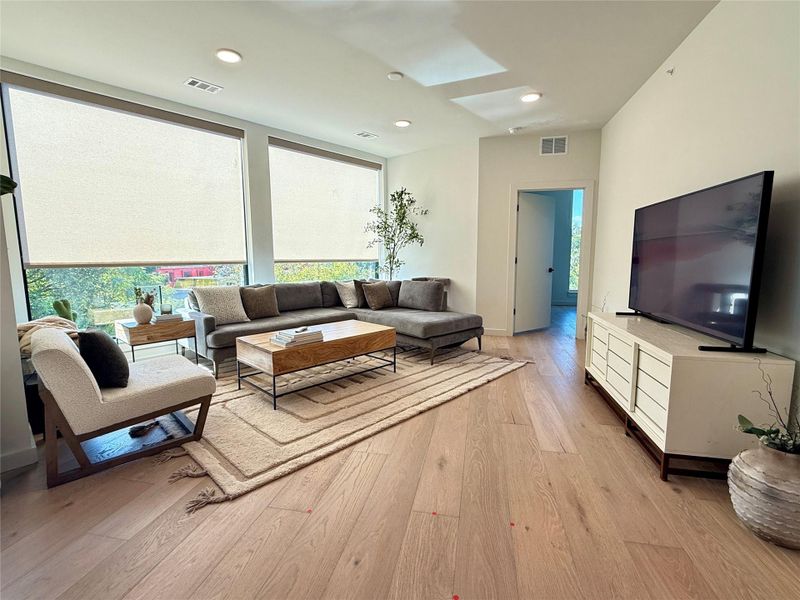Natural light floods this inviting living area, showcasing rich hardwood floors and an open concept layout.