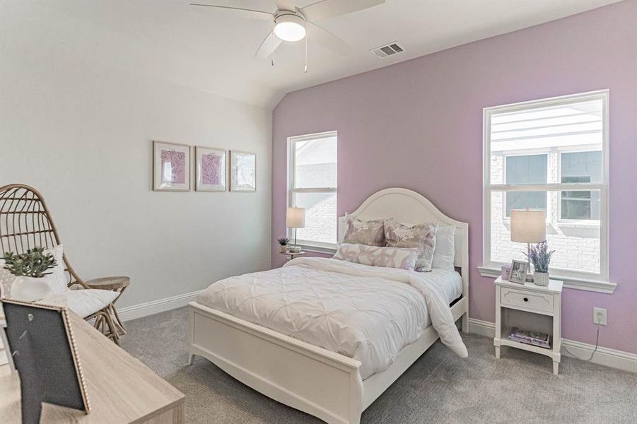 Carpeted bedroom featuring ceiling fan and lofted ceiling