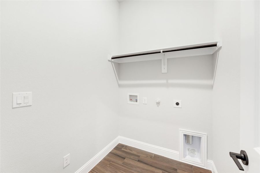 Laundry room with wall-mounted shelf, washer and dryer hookups, and wood-look tile flooring Laundry room with wall-mounted shelf, washer and dryer hookups, and wood-look tile flooring