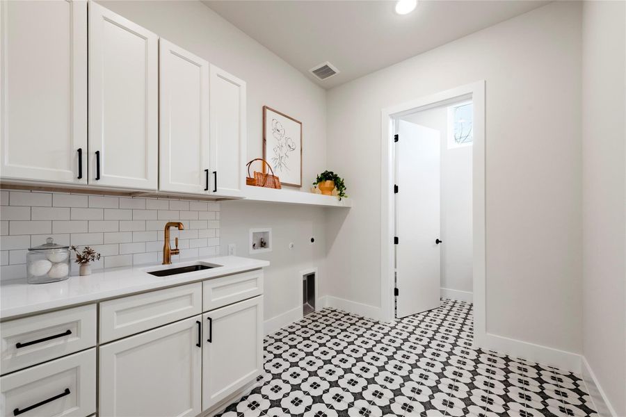 Laundry room featuring hookup for a washing machine, hookup for a gas dryer, a sink, visible vents, and cabinet space