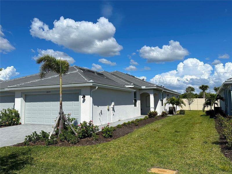Front exterior of a new home in Palm Lake at Coco Bay, Englewood, FL, highlighting curb appeal (Image 22).