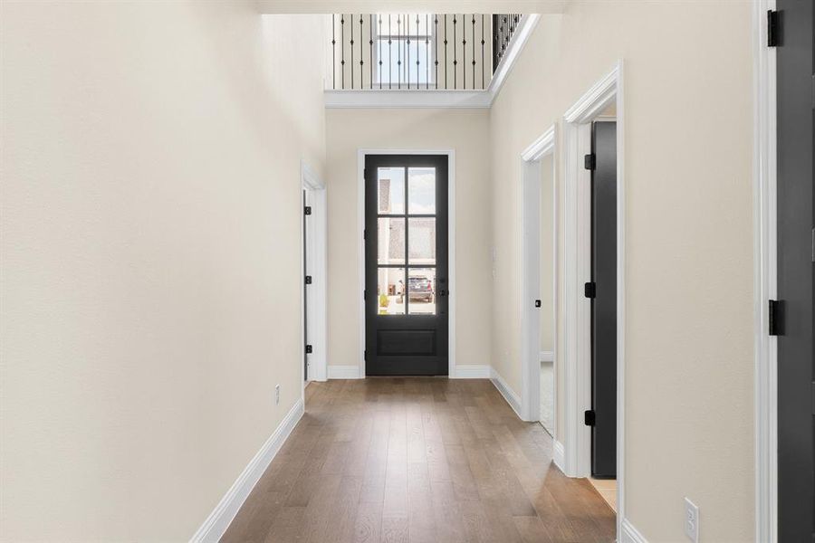 Entryway with light hardwood / wood-style flooring and a towering ceiling