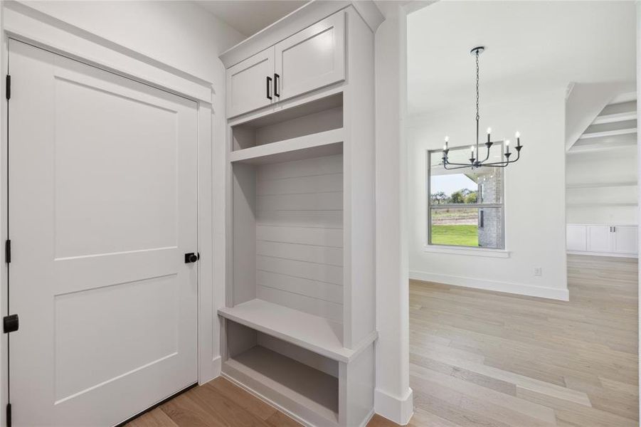 Mudroom featuring a chandelier and light hardwood / wood-style flooring