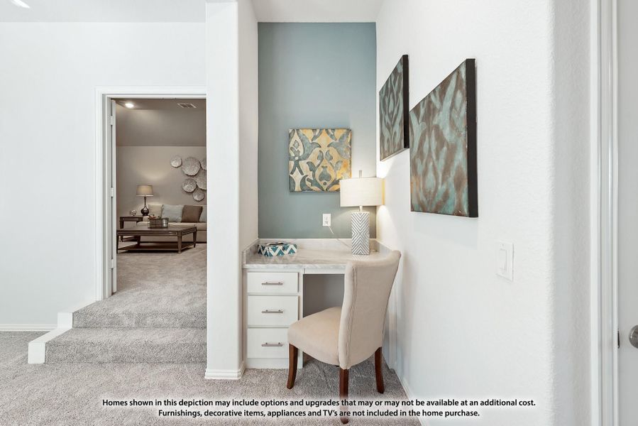 Built-in desk nook with white cabinets and light blue accent wall, with living room visible through doorway Built-in desk nook with white cabinets and light blue accent wall, with living room visible through doorway