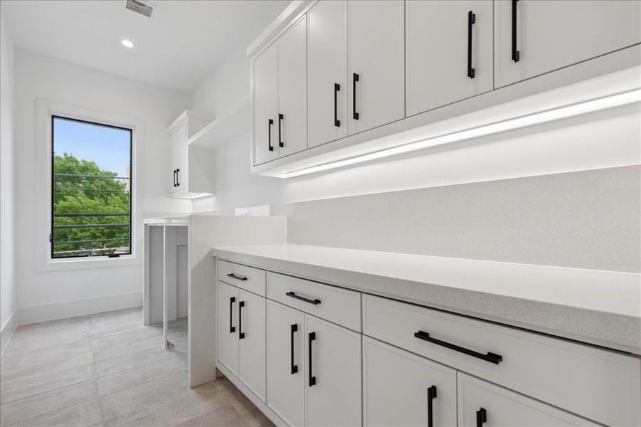 Kitchen with white cabinets and light tile floors