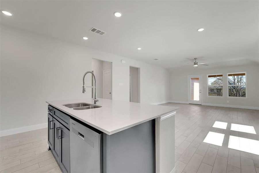 Kitchen featuring light wood-style flooring, a sink, visible vents, light countertops, and stainless steel dishwasher