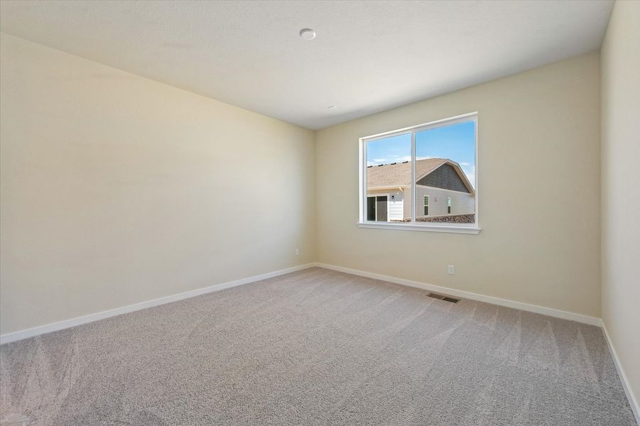 A room with a window and carpet.