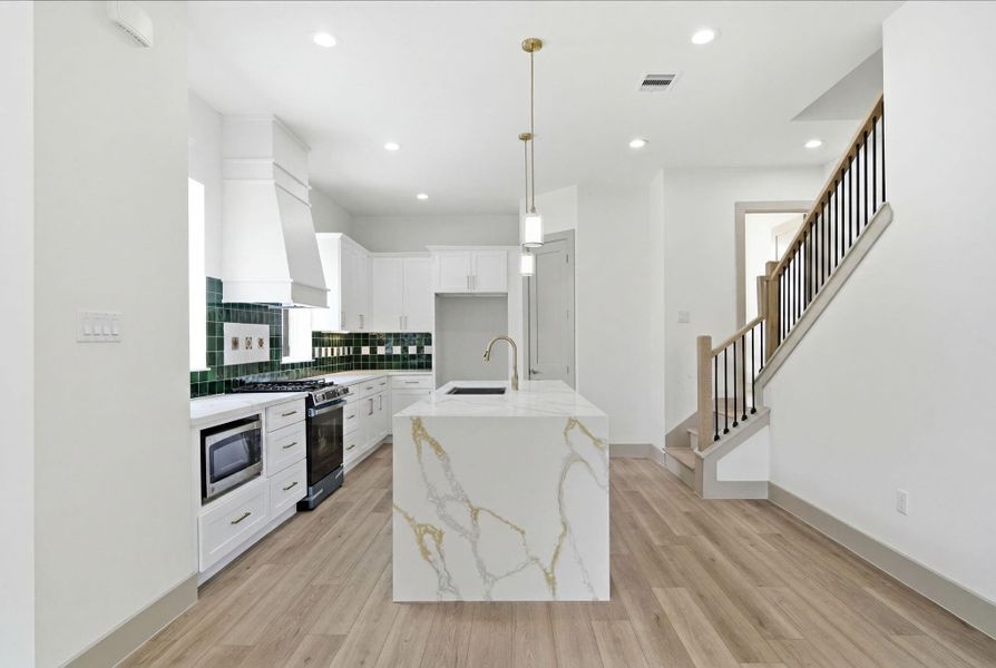 Tile features at kitchen backsplash.  32" single bowl stainless steel Ruvati Workstation kitchen sink. LARGE walk-in PANTRY. Quartz countertops