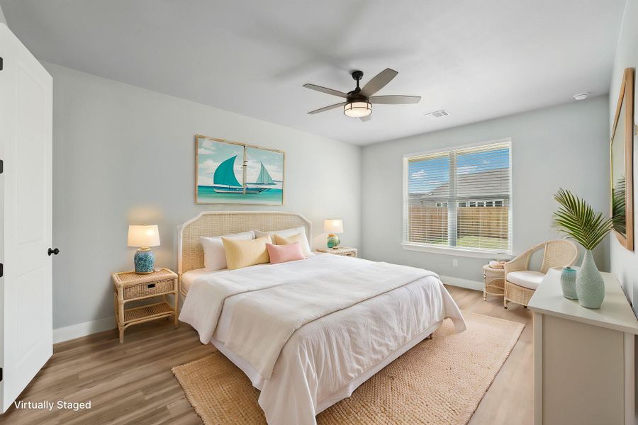 Virtually Staged Primary Bedroom with visible vents, baseboards, light wood-style flooring, and a ceiling fan