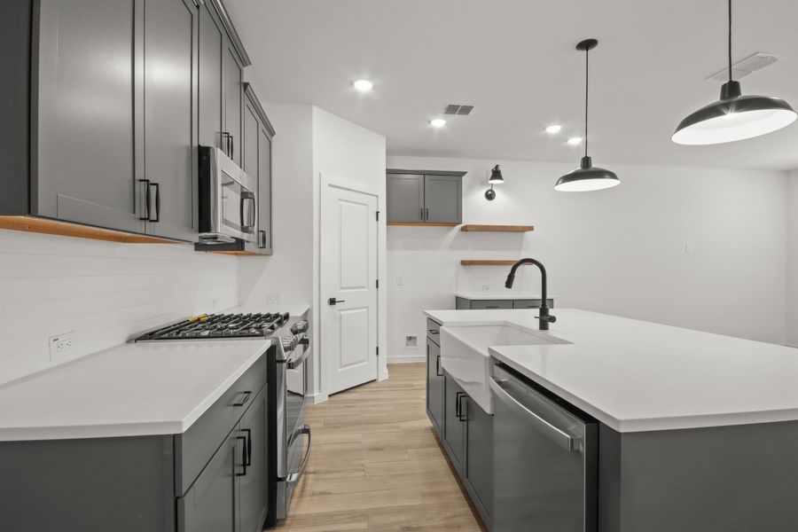Stylish kitchen with grey cabinets and quartz counters (*Photo not of actual home and used for illustration purposes only.) Stylish kitchen with grey cabinets and quartz counters (*Photo not of actual home and used for illustration purposes only.)