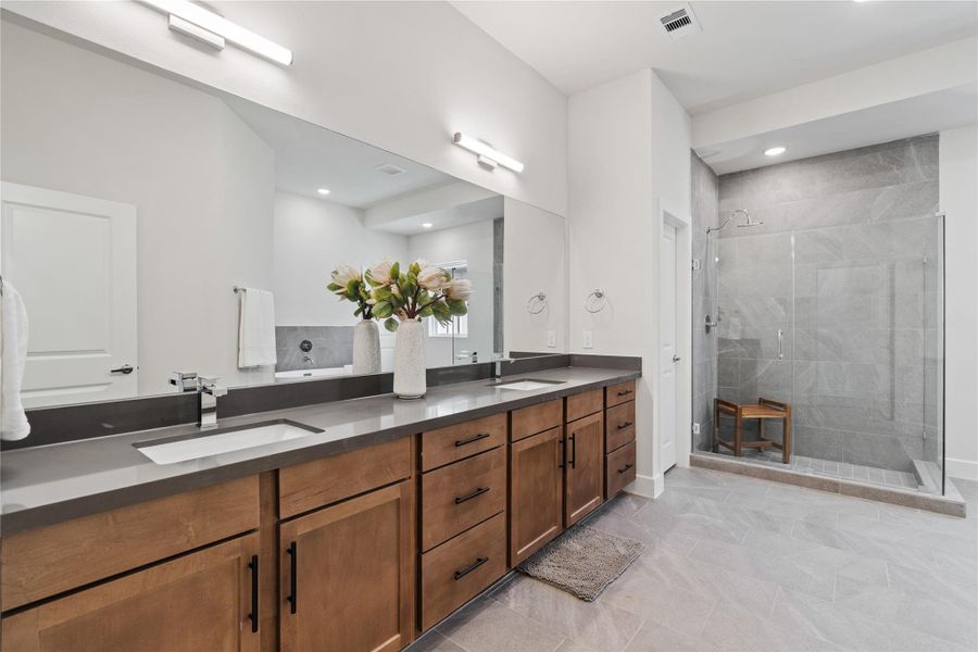 A primary bath of this size is uncommon at this price point, with a wide double-sink vanity and glass-enclosed shower wrapped in large format tile. A primary bath of this size is uncommon at this price point, with a wide double-sink vanity and glass-enclosed shower wrapped in large format tile.