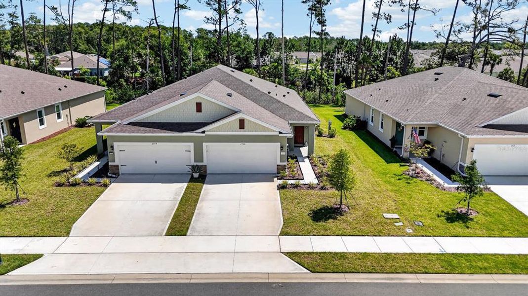 Front exterior of a new home in Halifax Plantation Villas, Ormond Beach, FL, highlighting curb appeal (Image 24).