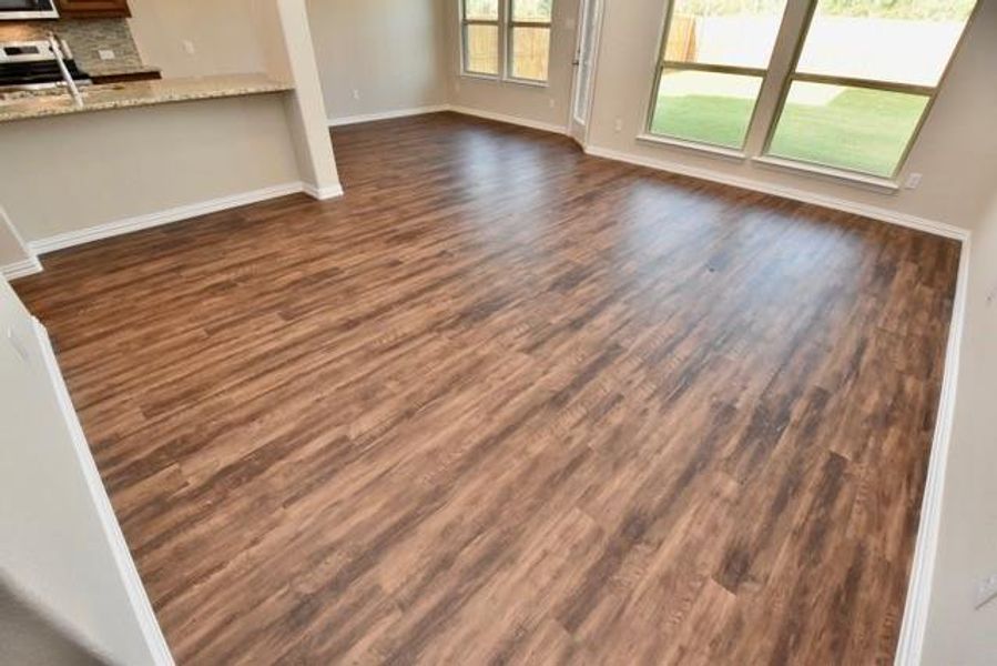 Kitchen featuring light stone countertops, brown cabinets, tasteful backsplash, and recessed lighting Kitchen featuring light stone countertops, brown cabinets, tasteful backsplash, and recessed lighting