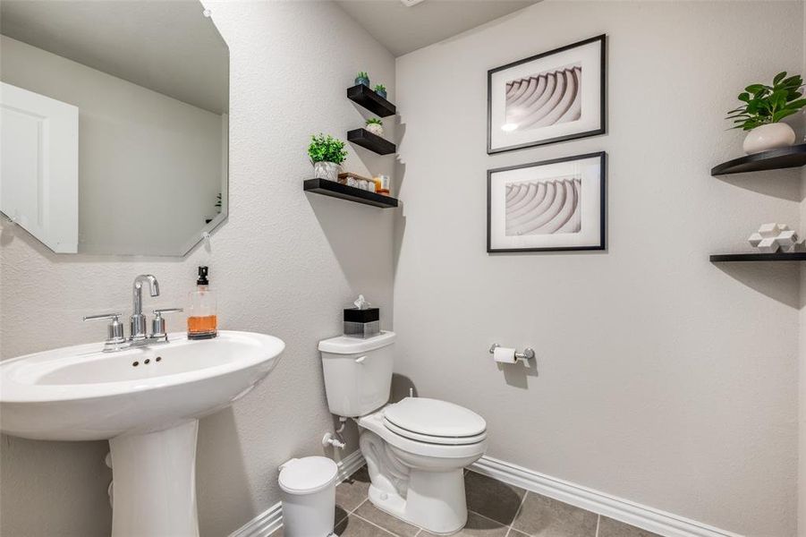 Half bath with tile patterned floors and a textured wall Half bath with tile patterned floors and a textured wall