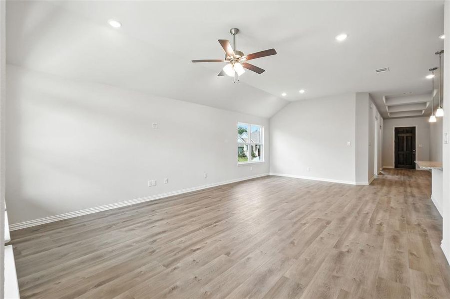 Unfurnished living room with a ceiling fan, recessed lighting, light wood-style flooring, and vaulted ceiling