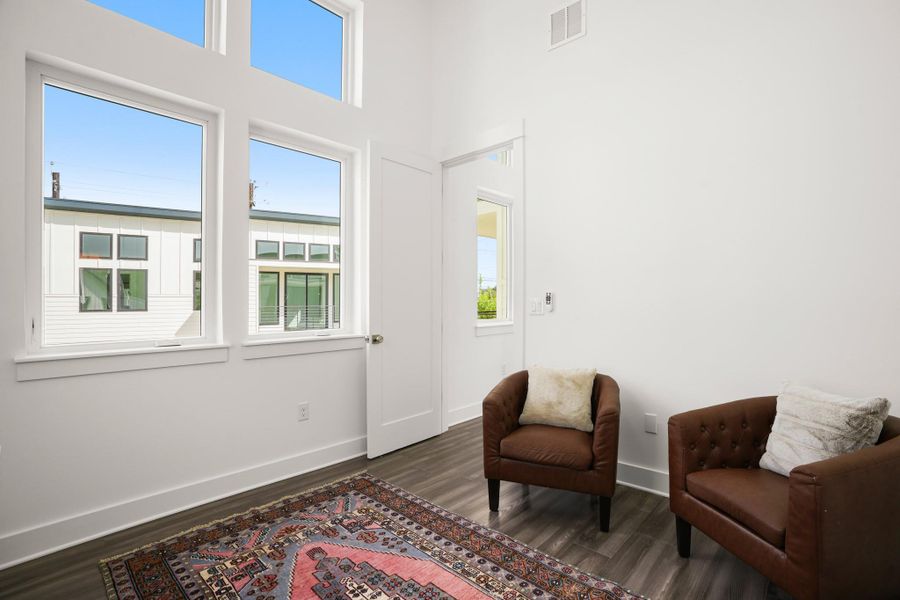 Tall windows and ample natural light define this cozy interior space. Tall windows and ample natural light define this cozy interior space.