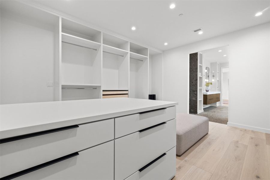 Walk in closet with light wood finished floors