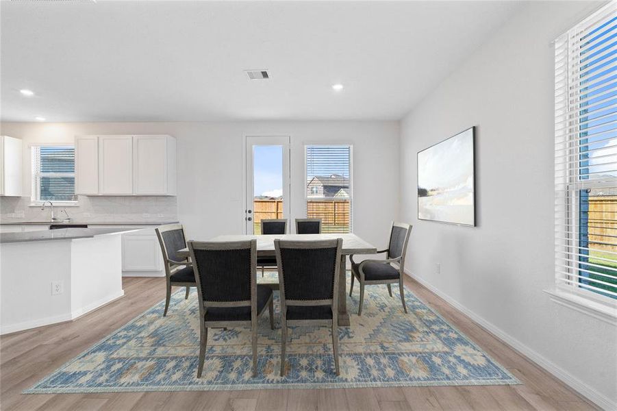 This lovely dining area is perfect for starting the day out on the right foot!  This space showcases custom paint, high ceilings, recessed lighting, large windows adding to the ample natural light, and tile flooring!