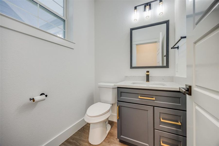 Bathroom featuring hardwood / wood-style floors, vanity, and toilet