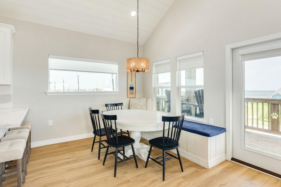 Sunlit dining space is positioned to capture coastal views and offers convenient access to the covered balcony for indoor-outdoor living.
