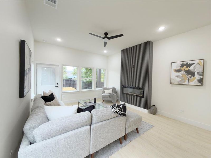 Living area with wood finished floors, a fireplace, recessed lighting, and a ceiling fan
