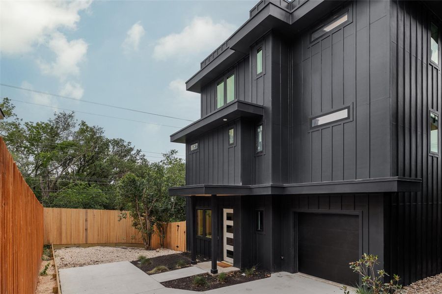 View of front of property featuring board and batten siding and an attached garage View of front of property featuring board and batten siding and an attached garage