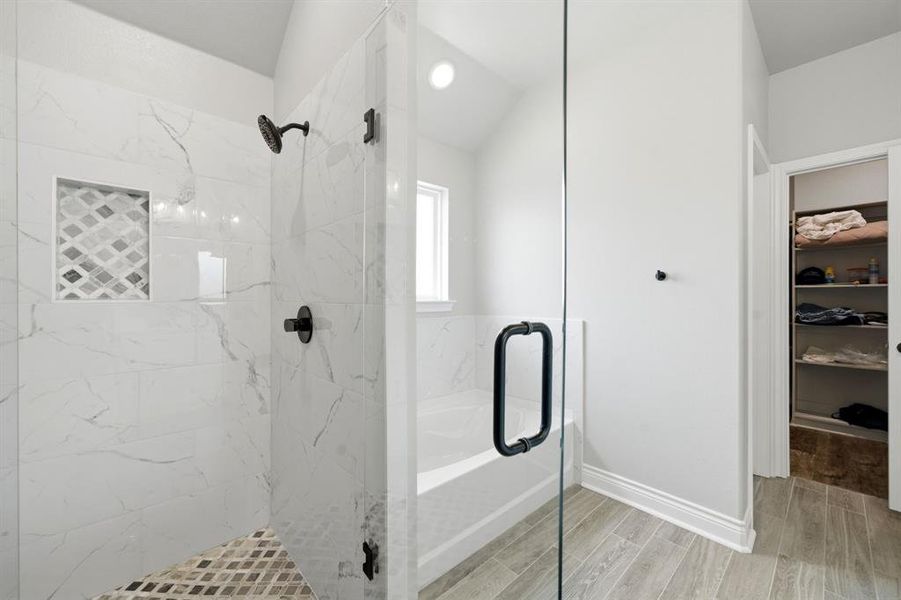 Full bathroom with a marble finish shower, wood tiled floors, and a bath