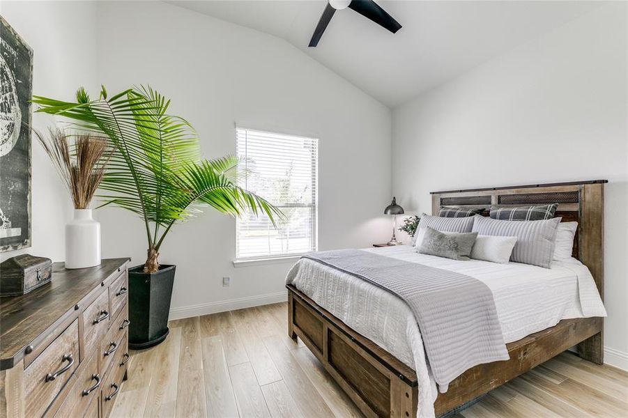 Bedroom featuring lofted ceiling, ceiling fan, and light wood-type flooring