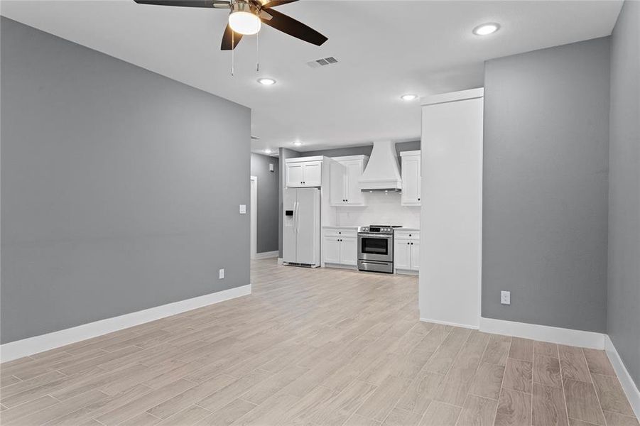 Unfurnished living room featuring light wood-style flooring, recessed lighting, and a ceiling fan Unfurnished living room featuring light wood-style flooring, recessed lighting, and a ceiling fan